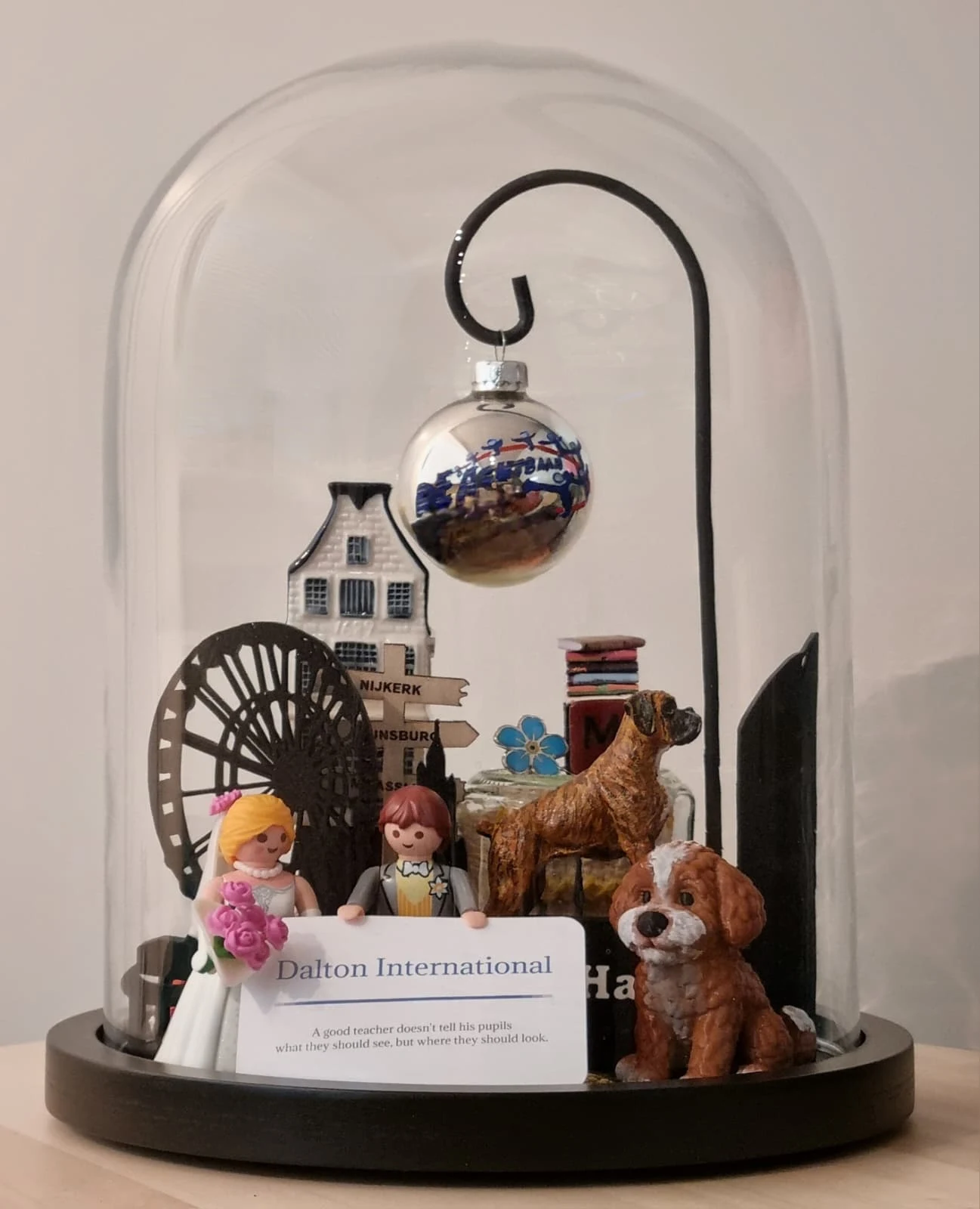 Stolp met een speelgoed bruidspaar, een hondje, een grachtenpandje, een kerstbal en een kaartje van Dalton International.